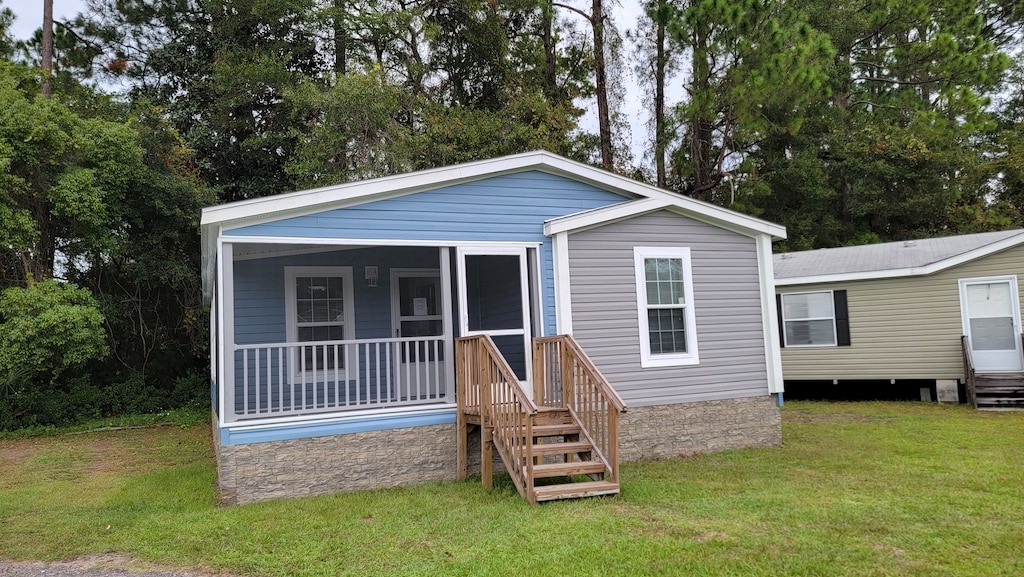 outside view of the zack flower manufactured home. Blue exterior, sitting on green grass.