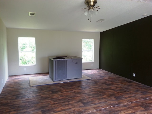 A spacious living room with an uninstalled AC unit.