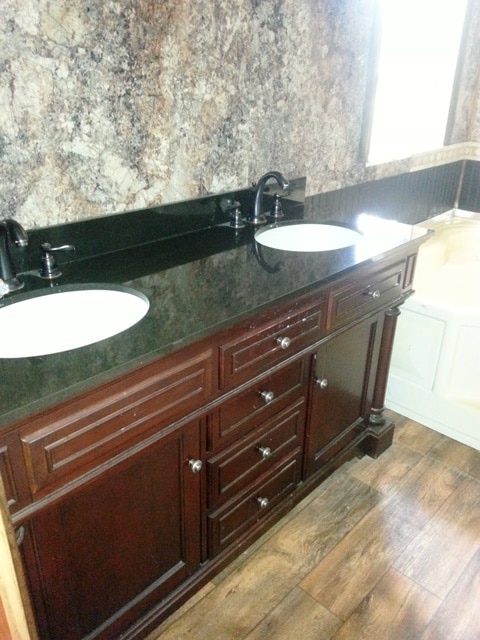 A bathroom vanity with double sinks and wooden cabinets.
