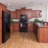 The Riley model's kitchen featuring wooden cabinets and black appliances