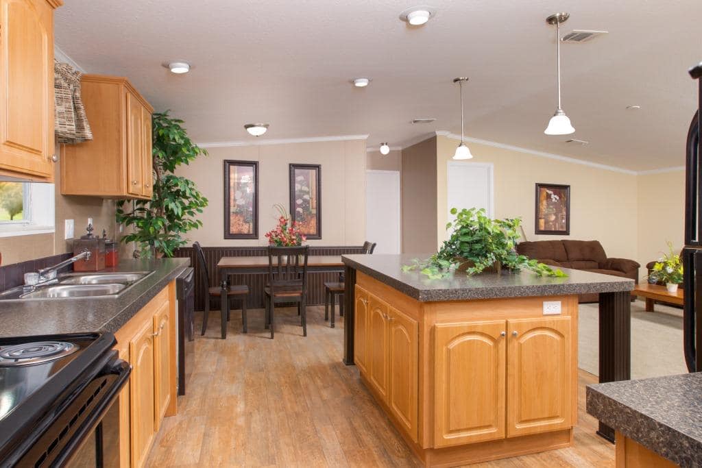 A manufactured home consisting of a kitchen island, dining table, and living room.