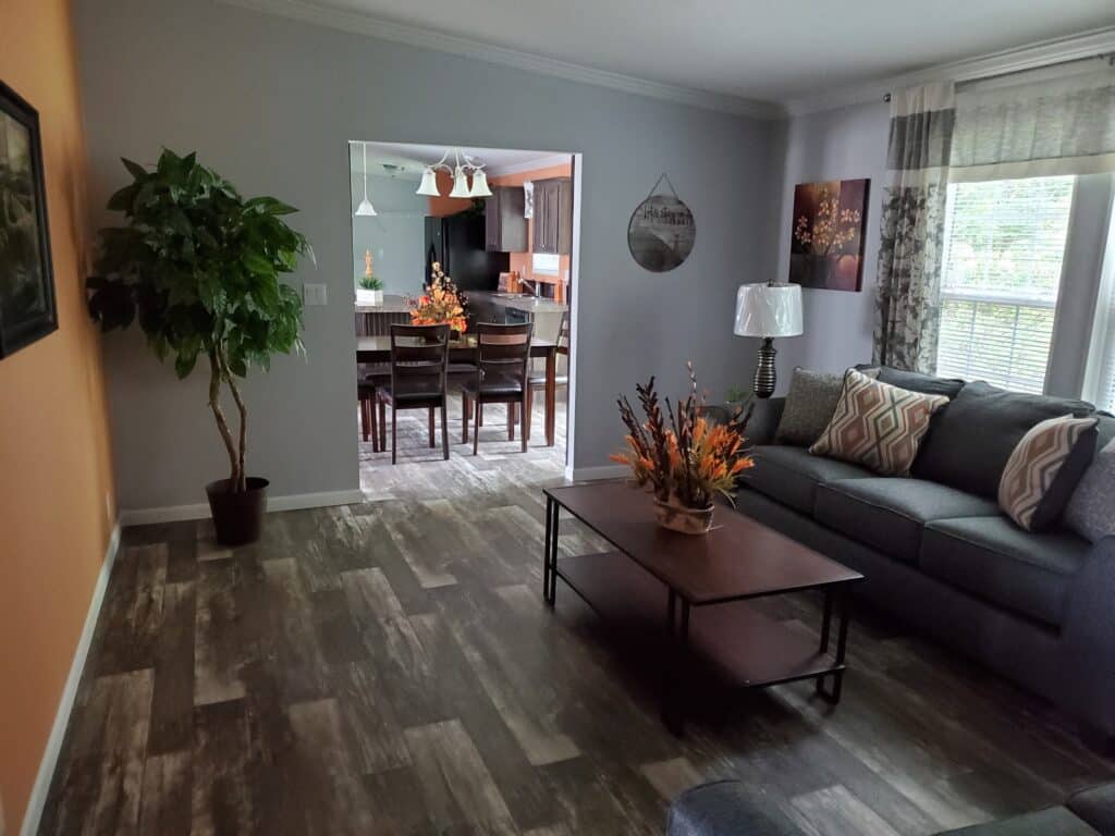 A living room consisting of a coffee table and couch. The living room is connected to the dining room.